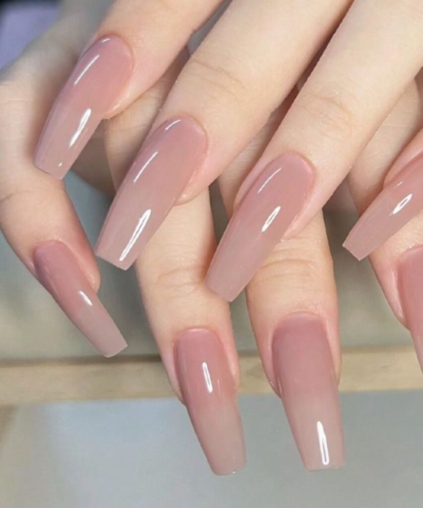 long acrylic nails in coffin shape with blush pink color on white marble background