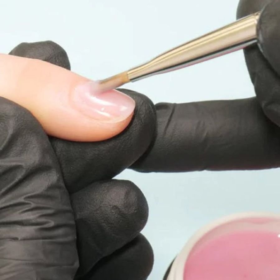 acrylic brush picking up acrylic powder and liquid bead for nail application