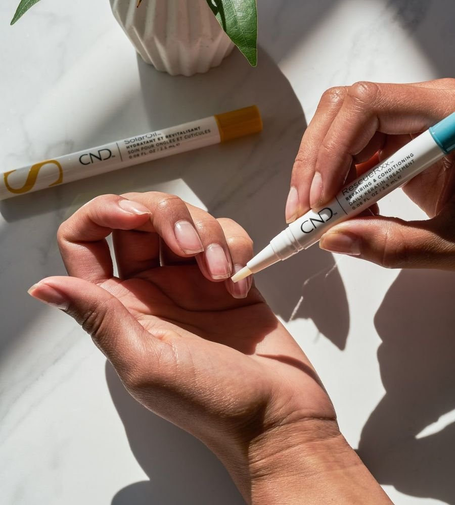 applying cuticle oil to maintain acrylic nails at home